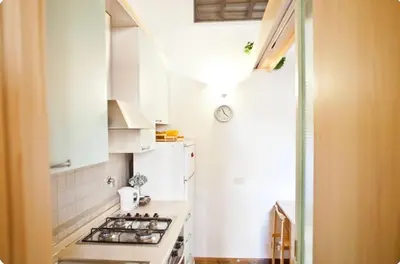 a white kitchen with a stove and a refrigerator at Piazza Argentina/Pantheon in Rome