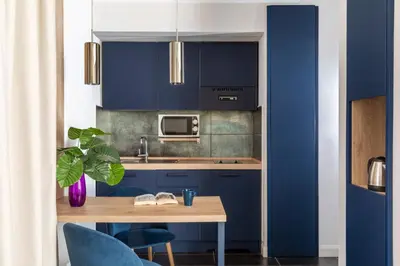 a kitchen with blue cabinets and a wooden table at Patrizia Romana Palace in Rome