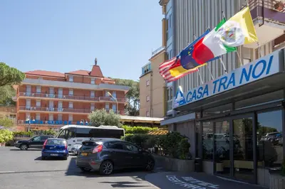 a parking lot with cars parked in front of a hotel at Hotel Casa Tra Noi in Rome