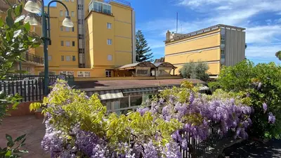 a yellow building with purple flowers in a garden at Hotel Casa Tra Noi in Rome