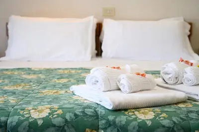 a pile of towels sitting on top of a bed at Hotel Casa Tra Noi in Rome