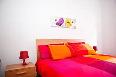 a bedroom with a bed with colorful sheets and a lamp at Viale Trastevere 108 in Rome
