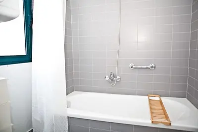 a bathroom with a bath tub with a wooden shelf on it at Viale Trastevere 108 in Rome