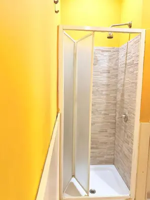 a shower with a glass door in a bathroom at Guest House Hola Roma in Rome