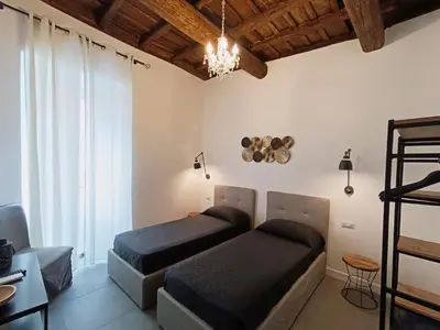 a bedroom with two beds and a chandelier at La tua casa a ViadelCorso in Rome