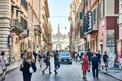 a group of people walking down a busy city street at La tua casa a ViadelCorso in Rome