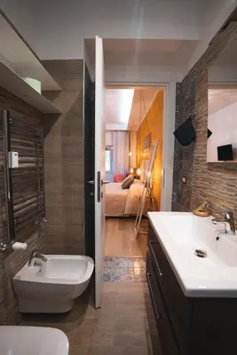 a bathroom with a sink and a toilet and a bedroom at Verrazzano 37 Guest House in Rome