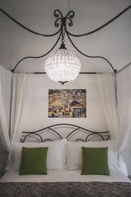 a bedroom with a large bed with a chandelier at Verrazzano 37 Guest House in Rome