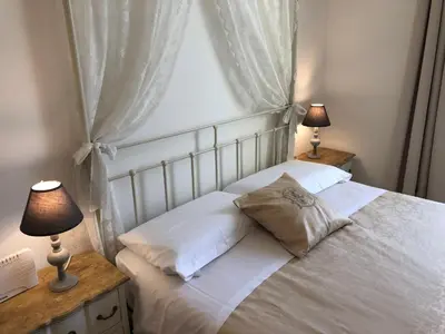 a bedroom with a white bed with two lamps at Art Atelier San Pietro in Rome