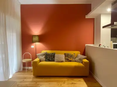 a yellow couch in a room with a red wall at Atelier San Pietro in Rome