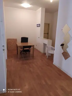 a living room with a table and chairs and a wall at Marco's House in Rome