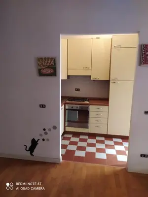a kitchen with white cabinets and a checkered floor at Marco's House in Rome