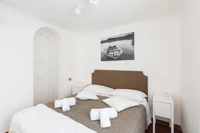 a bedroom with a bed with white sheets and pillows at A World Aparts - 143 Sistina in Rome