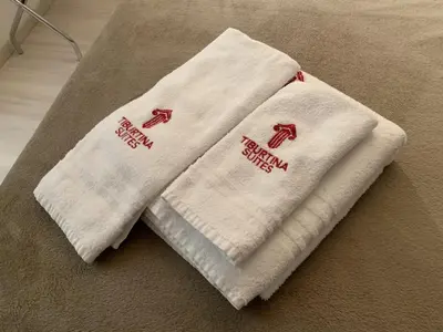 two white towels sitting on top of a floor at Tiburtina Suites, Roma in Rome