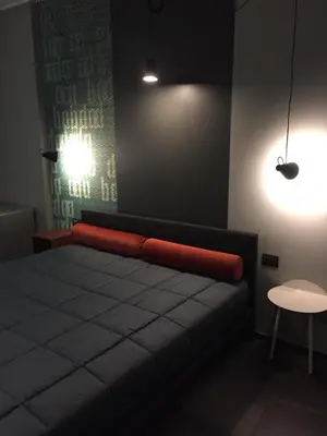 a bedroom with a bed with a red blanket on it at Tiburtina Suites, Roma in Rome