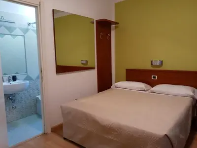 a bedroom with a bed and a bathroom with a sink at La Casa Dell'Arte in Rome