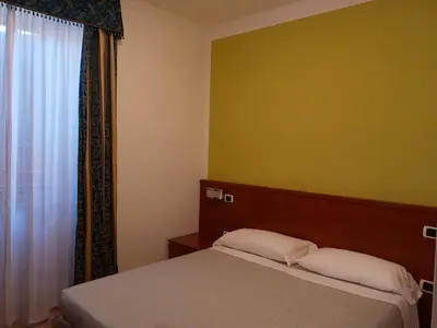 a small bedroom with a bed and a window at La Casa Dell'Arte in Rome