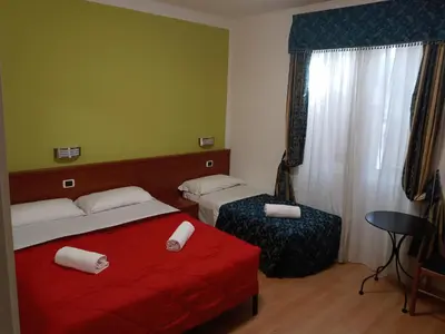 a hotel room with two beds and a red blanket at La Casa Dell'Arte in Rome