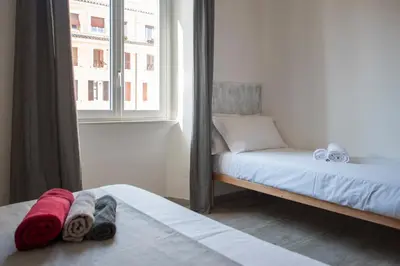 a bedroom with two beds and a window at Raffaela's Suite & Rooms Vatican Guest House in Rome