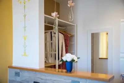 a vase of flowers on a table in a closet at Raffaela's Suite & Rooms Vatican Guest House in Rome