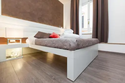 a white bed sitting in a room with a window at Town House Fontana Di Trevi in Rome