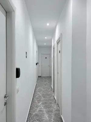 an empty corridor with white walls and floors and white doors at Pascià Rooms in Rome