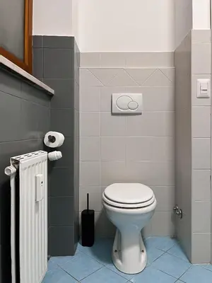 a bathroom with a white toilet and some towels at Pascià Rooms in Rome