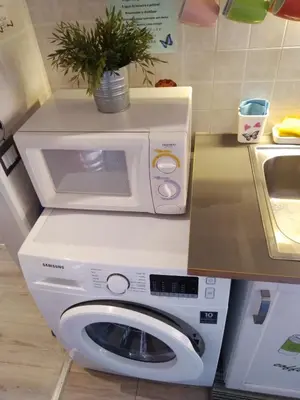 a kitchen with a washing machine and a microwave at Domus Ferruccio in Rome