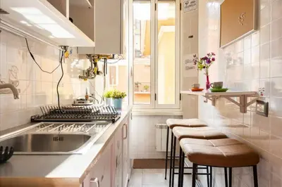 a kitchen with a sink and a counter with stools at Domus Ferruccio in Rome