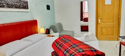 a bedroom with a bed and a chair and a door at I Dormienti in Rome