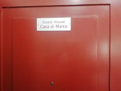a sign on a door that reads guest house casa chi marco at Casa di Marco a Trastevere in Rome