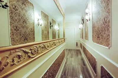 a hallway with gold railings and paintings on the walls at Impero Vaticano Suites Guest House in Rome