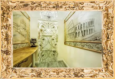 an ornate gold mirror in a room with paintings at Impero Vaticano Suites Guest House in Rome