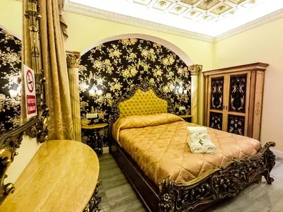 a bedroom with a bed with a black and gold at Impero Vaticano Suites Guest House in Rome