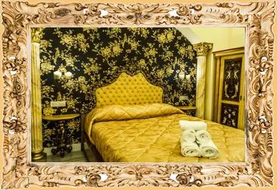 a bedroom with a gold bed in a mirror at Impero Vaticano Suites Guest House in Rome