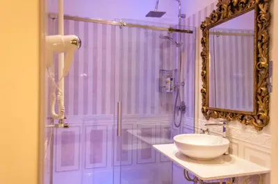 a bathroom with a sink and a shower with a mirror at Impero Vaticano Suites Guest House in Rome
