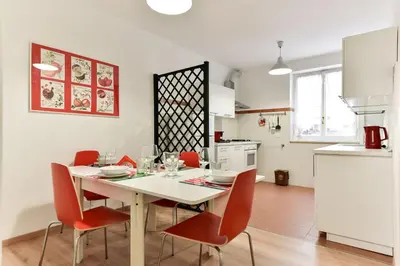 a kitchen and dining room with a table and chairs at Red & White Vatican Apartment in Rome