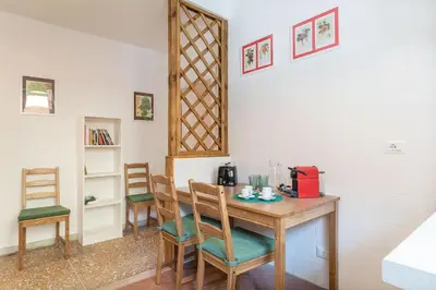 a room with a wooden table with chairs at Red & White Vatican Apartment in Rome