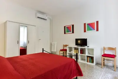 a bedroom with a red bed and a television at Red & White Vatican Apartment in Rome