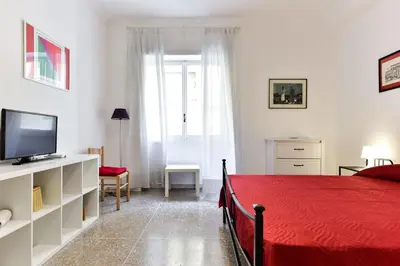 a bedroom with a red bed and a television at Red & White Vatican Apartment in Rome