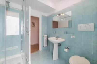 a bathroom with a sink and a toilet and a shower at Red & White Vatican Apartment in Rome