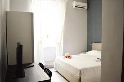 a bedroom with a bed and a tv and a window at Colosshouse guest house in Rome