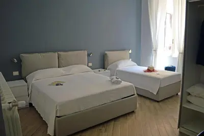 a bedroom with two beds and a window at Colosshouse guest house in Rome