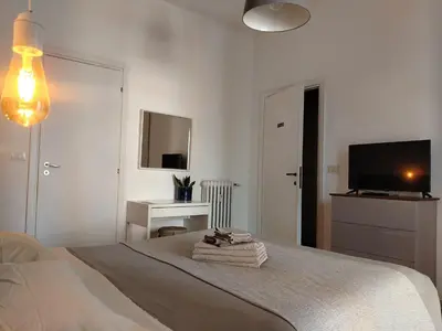 a white bedroom with a bed and a television at By Grace in Rome
