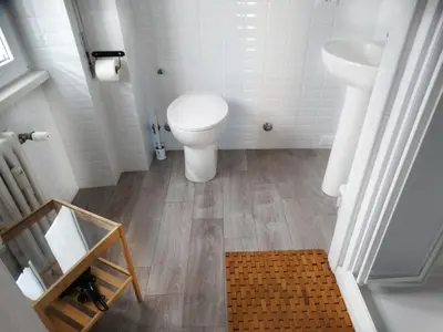 a white bathroom with a toilet and a sink at By Grace in Rome