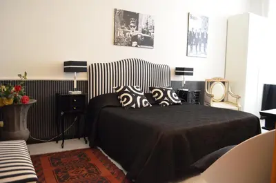a bedroom with a black and white bed and a chair at Sweetdreams Inn in Rome