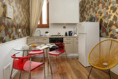 a kitchen with a table and chairs and a refrigerator at The right place 4U Grotte Apartment in Rome