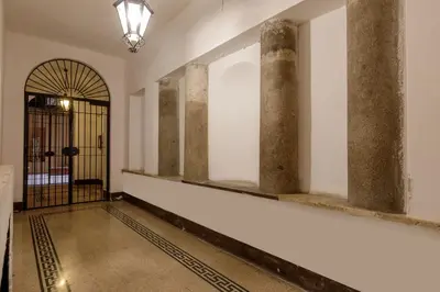 a hallway with columns and a door with a gate at The right place 4U Grotte Apartment in Rome