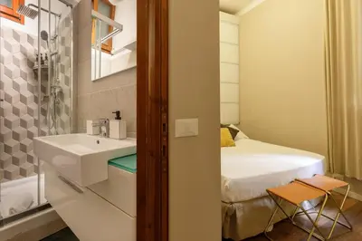 a small bathroom with a sink and a bed at The right place 4U Grotte Apartment in Rome