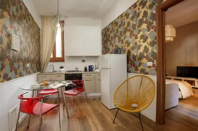 a kitchen with a table and chairs and a refrigerator at The right place 4U Grotte Apartment in Rome